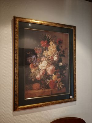une photo d'un vase de fleurs accrochée au mur