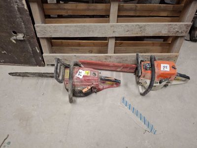 two chainsaws sitting next to each other on the floor