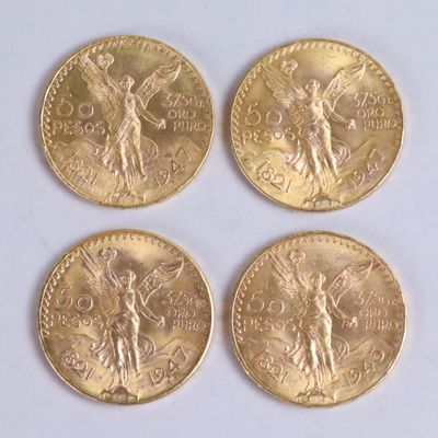 four gold coins with angels on them sitting on a white surface