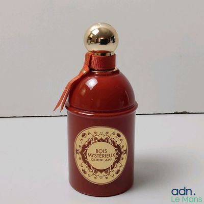 un flacon de parfum posé sur une surface blanche