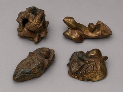 quatre figurines en bronze représentant des animaux et un oiseau, posées sur une table