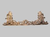 an image of a pair of ornate brass brackets on a gray background