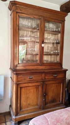 un vaisselier en bois avec des portes en verre dans une pièce