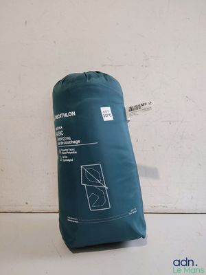 un gros plan d'un sac de couchage bleu posé sur une surface blanche
