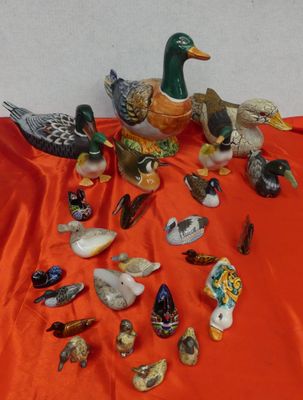 many different kinds of ducks on a red cloth