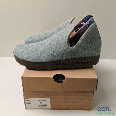 une paire de pantoufles grises posée sur une boîte, sur une surface blanche