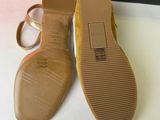 pair of women ' s shoes on a white surface next to an orange box