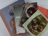 trois livres sont empilés sur une table