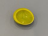 un bol jaune posé sur une table, avec une cuillère dedans