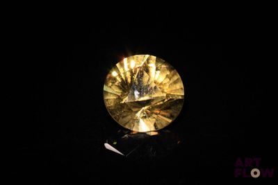 gros plan d'un diamant jaune sur une surface noire
