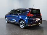 the rear end of a blue car parked in a showroom