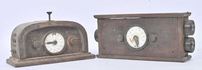 two clocks that are sitting side by side on a table