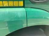a close up of a green truck with a yellow sticker on it
