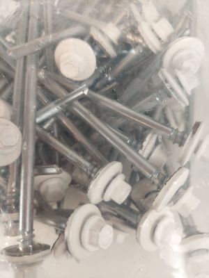 de nombreuses vis et écrous dans un récipient en plastique