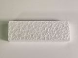 white rectangular stone on a white surface with a blue and white background
