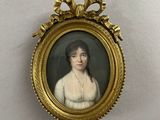 une vieille photo d'une femme en robe blanche dans un cadre doré