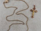a cross and a bell on a chain on a table