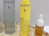three bottles of caudalie and a bottle of lotion sitting on a table
