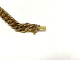 an image of a close up of a gold chain bracelet on a white surface