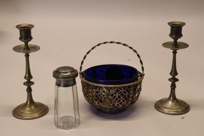 trois bougies et un panier posés sur une table, à côté d'une salière