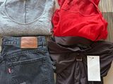 trois paires de jeans et un t-shirt posés par terre