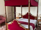 a four poster bed in a room with a chandelier
