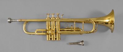 a gold trumpet sitting on top of a table next to a screw