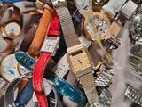 a pile of assorted watches and watches on a table