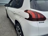 the rear end of a white car parked in a parking lot