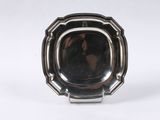 une assiette ancienne en argent sur laquelle figure le portrait d'une femme dans un miroir