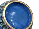 a blue vase with a gold rim sitting on a white surface