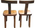 pair of wooden chairs sitting next to each other on a white surface