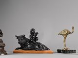 three statues of animals and a bird on a table