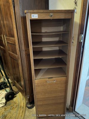 a tall wooden cabinet with a drawer in the corner