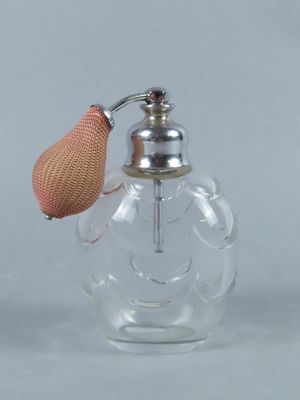 une petite bouteille en verre avec une poignée rose et un bouchon en métal
