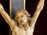 a statue of jesus on a cross with his hands up