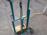 a green hand truck that is sitting in a parking lot
