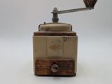 a small coffee grinder sitting on a white surface