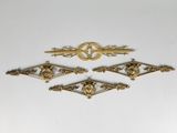 quatre ornements en métal plaqué laiton antique sur un fond blanc