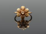 a close up of a gold ring on a reflective surface