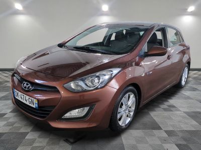La voiture marron est garée dans le garage, sur le sol à damier.