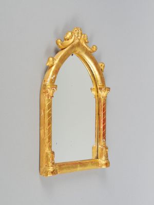 un miroir doré accroché au mur au-dessus d'un lavabo