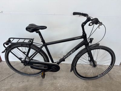 un vélo noir garé dans un garage, près d'un mur