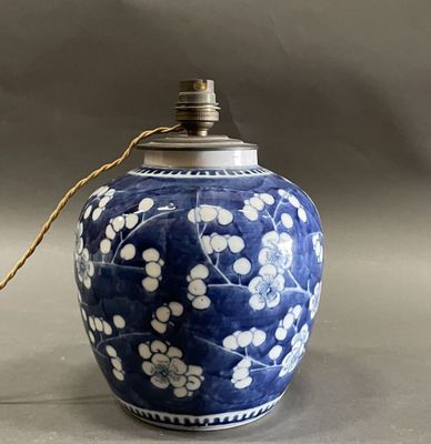 a blue vase with white flowers on it on a table