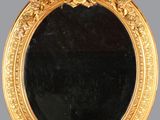 un miroir ancien dans un cadre doré, orné d'une tête de lion