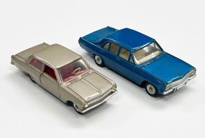 deux voitures jouets assises l'une à côté de l'autre sur une surface blanche