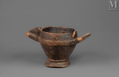 an old wooden bowl with a wooden handle on a gray surface
