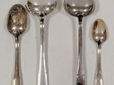 three spoons and two spoons sitting on a table