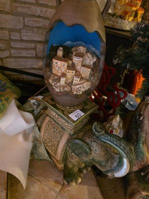 une statue représentant une tortue assise à côté d'un sapin de Noël