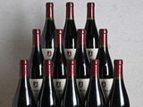 a bunch of bottles of wine sitting on top of a wooden table